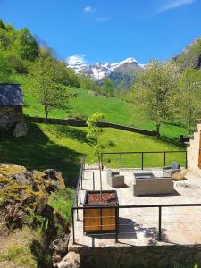 a house with a patio with a tree on a hill at Maison authentique in Gavarnie