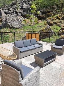 a patio with three couches and a table and chairs at Maison authentique in Gavarnie