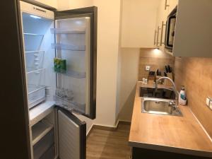 eine Küche mit Kühlschrank und offener Tür in der Unterkunft Royal Blue Grand Suite No 1 in Piräus