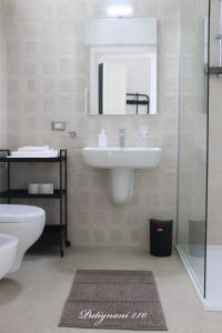 a bathroom with a sink and a toilet and a mirror at Putignani 210 Apartment in Bari +41 photos