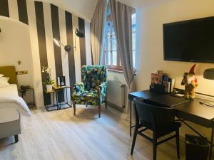 a room with a bed and a desk and a chair at Hotel Jagdhof Glashütte in Bad Laasphe
