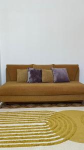 ein braunes Sofa im Wohnzimmer mit zwei Kissen in der Unterkunft Кабанбай батыра 58б/7 in Astana