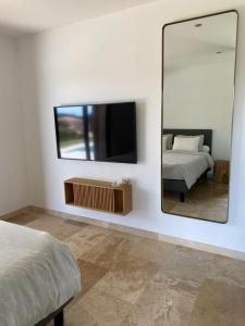 a bedroom with a mirror and a bed and a tv at Villa de charme avec piscine à Ajaccio in Alata
