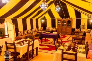 a dining room with tables and chairs in a tent at Sahara Glamping in Merzouga