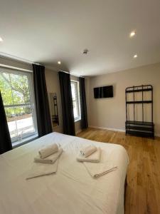 a bedroom with a white bed with two towels on it at George Canning Denmark Hill, London in London