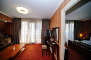 a hotel room with a bed and a desk with a television at Sharden Villa Boutique Hotel in Tbilisi City