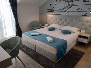 a bedroom with a large bed and two chairs at Hotel Perla in Dubrovnik
