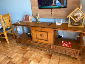 a wooden desk with a television on top of it at REFÚGIO DA SEREIA ARIEL in Mongaguá