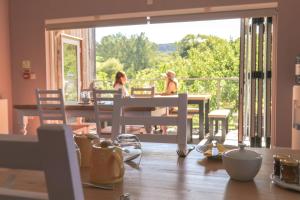 two women sitting at a table in a dining room at Godshill Park Cottages in Godshill