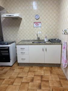 a kitchen with a sink and a stove at REFÚGIO DA SEREIA ARIEL in Mongaguá