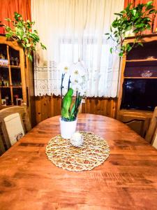 a wooden table with a vase of flowers on it at Apartmani Ankica in Crikvenica