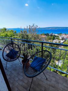 two chairs on a balcony with a view of the water at Apartmani Ankica in Crikvenica