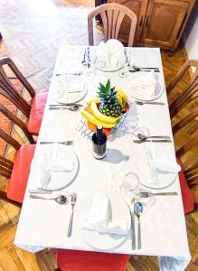 a table with white plates and a bowl of fruit on it at Apartmani Ankica in Crikvenica