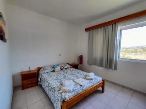 1 dormitorio con 1 cama con toallas en East View Appartment (Thanasis 1), en Kalavárda
