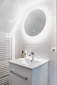 bagno bianco con lavandino e specchio di Herengracht Private room with canal view ad Amsterdam
