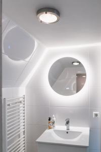een witte badkamer met een wastafel en een spiegel bij Herengracht Private room with canal view in Amsterdam