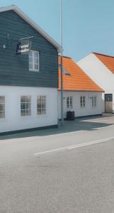 a building with a sign on it next to a street at Tversted Strandpark in Bindslev