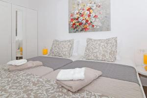 a bedroom with two beds and a painting on the wall at Studio Apartman Karlita in Slano