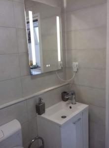 a white bathroom with a sink and a mirror at Stone Guest House in Split