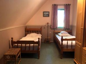 two twin beds in a room with a window at Szendergő - Apartman Hajós pincefalu in Hajós