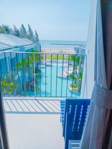 balcón con vistas a la piscina en HATCHAO HERITAGE BEACH FRONT RESORT, en Ban Hat Cha Samran