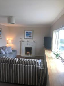 a living room with a couch and a fireplace at The Jewel of the Moray Firth in Lossiemouth