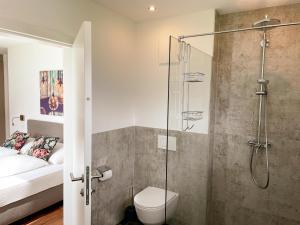 un letto e un bagno con doccia e servizi igienici. di TheView Ahorn a Fügen