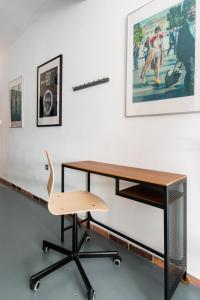 a desk with a chair and a picture on the wall at Explore a New Arts District from a Hip Studio Flat in Athens