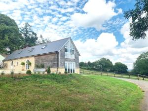 a house on a grassy hill with a fence at The Barn in Gillingham