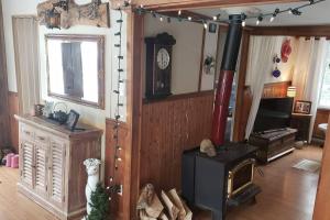 un salon avec un poêle à bois dans une pièce dans l'établissement Chalet - Les Tourterelles - très agréable pour couple et famille ., à Saint-Côme