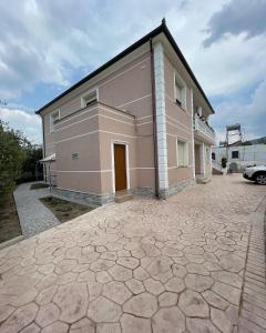 a large house with a brick driveway in front of it at Rent rooms Loren in Vlorë