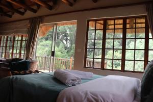 a bedroom with two pillows on a bed with windows at Hawklee Country House in Fort Nottingham