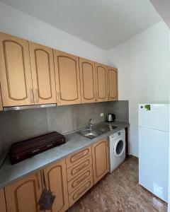 a kitchen with a sink and a white refrigerator at Rent rooms Loren in Vlorë