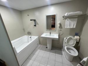 a bathroom with a tub and a toilet and a sink at 苓旅萬年-LIN INN Wan Nian in Taipei