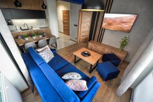 a living room with a blue couch and a table at Apartament Komfort 17 in Zator