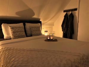a bedroom with a bed with two glasses on it at Secret Wellness Droombos in Holten