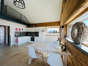 a kitchen with a wooden table and white chairs at Chalet Buron in Kaufbeuren