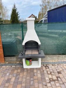 a barbecue cooker sitting on a brick patio at Apartamenty na Źródlanej in Stężyca