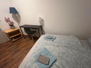 1 dormitorio con 1 cama con 2 toallas en Zimmer in Innenstadtwohnung, en Würzburg