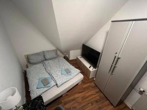 a small bedroom with a bed and a television at Zimmer in Innenstadtwohnung in Würzburg