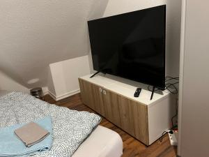 telewizor z płaskim ekranem siedzący na szafce w obiekcie Zimmer in Innenstadtwohnung w mieście Würzburg