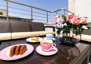 a table with two plates of food and a vase of roses at Cheers Vera Edition Hotel in Istanbul