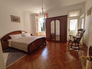 a bedroom with a bed and a chair in it at Villa Arancia in Dubrovnik