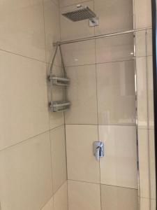 a shower with a glass door in a bathroom at Urban Awe Apartment- iTowers 18th Floor in Gaborone +19 photos