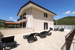 eine Terrasse mit schwarzen Stühlen und ein Gebäude in der Unterkunft Acquasanta Relais in Laureana Cilento