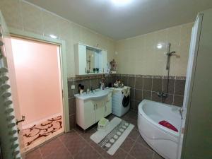 ein Badezimmer mit einer Badewanne, einem Waschbecken und einer Badewanne in der Unterkunft Large Aparment NilResidance in Bursa