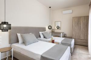 Un dormitorio con una gran cama blanca y un sofá. en ANASTASIOS HOUSE STEGNA - UP FLOOR, en Archangelos