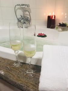 zwei Gläser Wein auf einer Theke neben einer Badewanne in der Unterkunft PAZO DE CÍCERE in Cícere