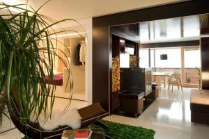 un soggiorno con un grande specchio e una pianta di Kar Design Appartements a Lech am Arlberg