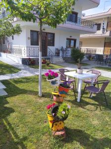 a garden with a table and chairs and flowers at Stefanie's Rooms in Asprovalta